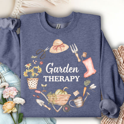 Dark navy crewneck sweatshirt with "Garden Therapy" text surrounded by a watercolor wreath of gardening tools and flowers.
