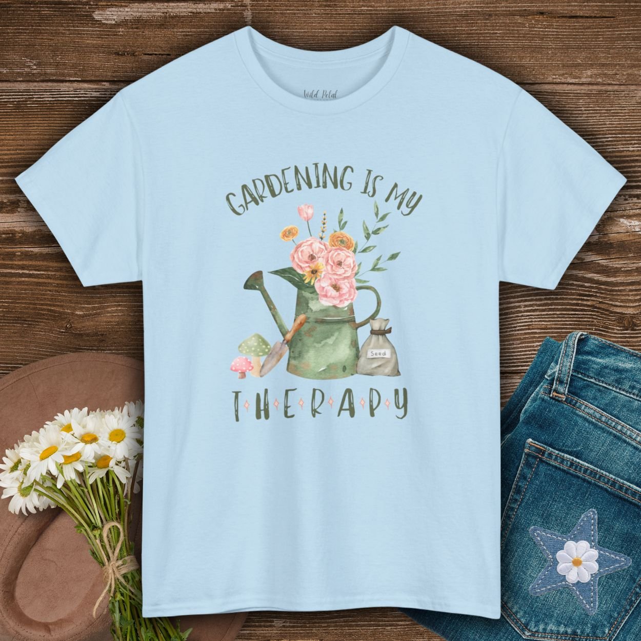 Light blue Gildan 5000 t-shirt with "Gardening Is My Therapy" text and watercolor watering can, flowers, and trowel design.