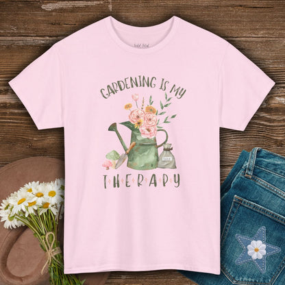 Light pink S-size cotton tee with "Gardening Is My Therapy" and watercolor watering can, flowers, trowel, seed bag design.