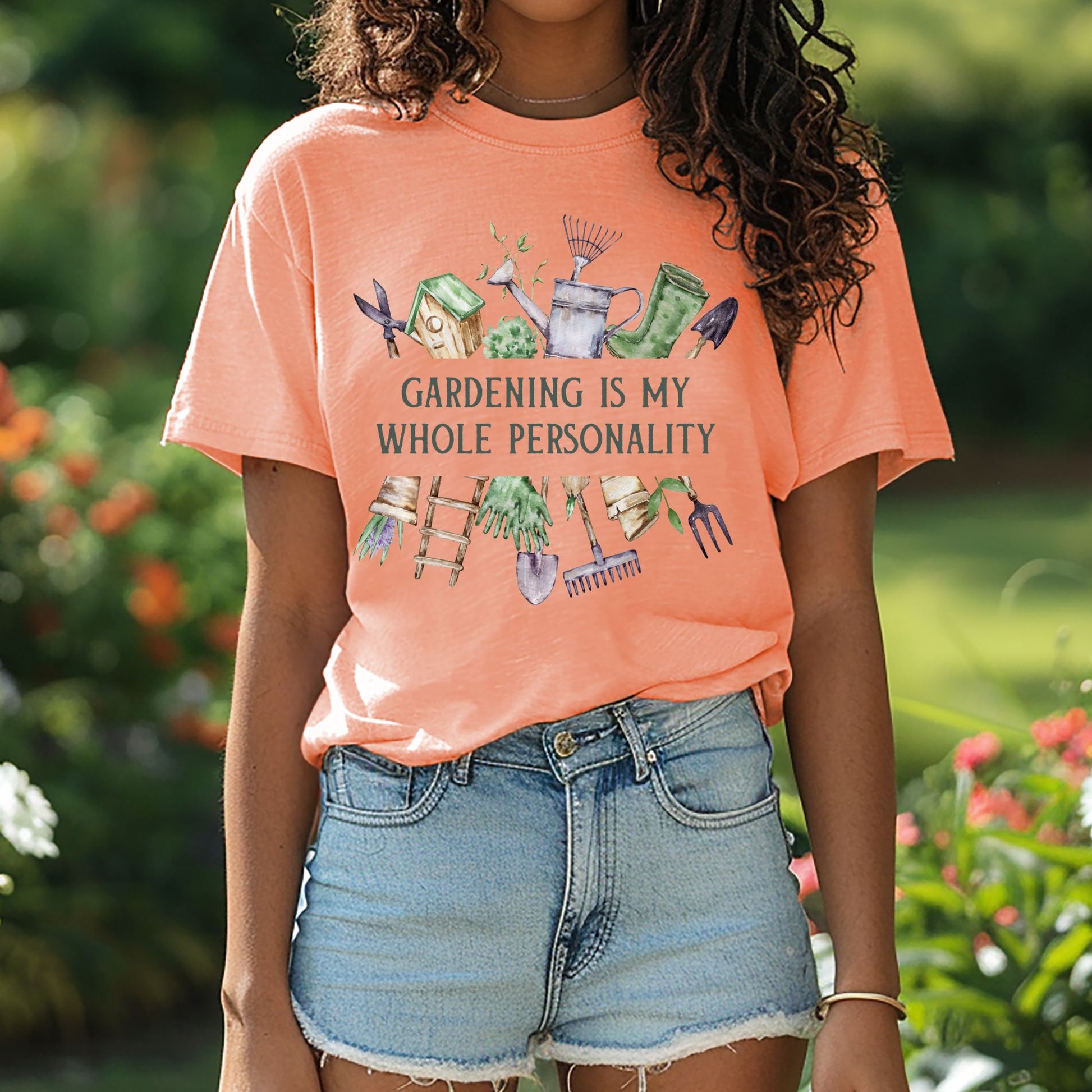 Peach t-shirt with "Gardening Is My Whole Personality" text and watercolor gardening tools.