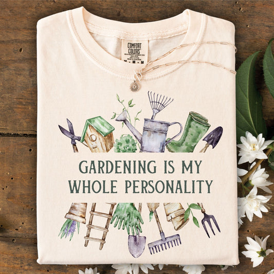 Ivory Comfort Colors t-shirt with "Gardening Is My Whole Personality" text and watercolor gardening tools.