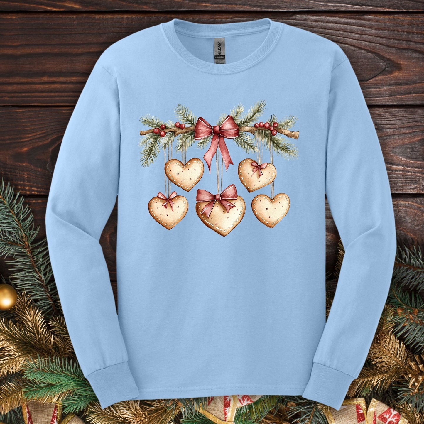 Light blue S long sleeve tee with a watercolor gingerbread heart garland design.