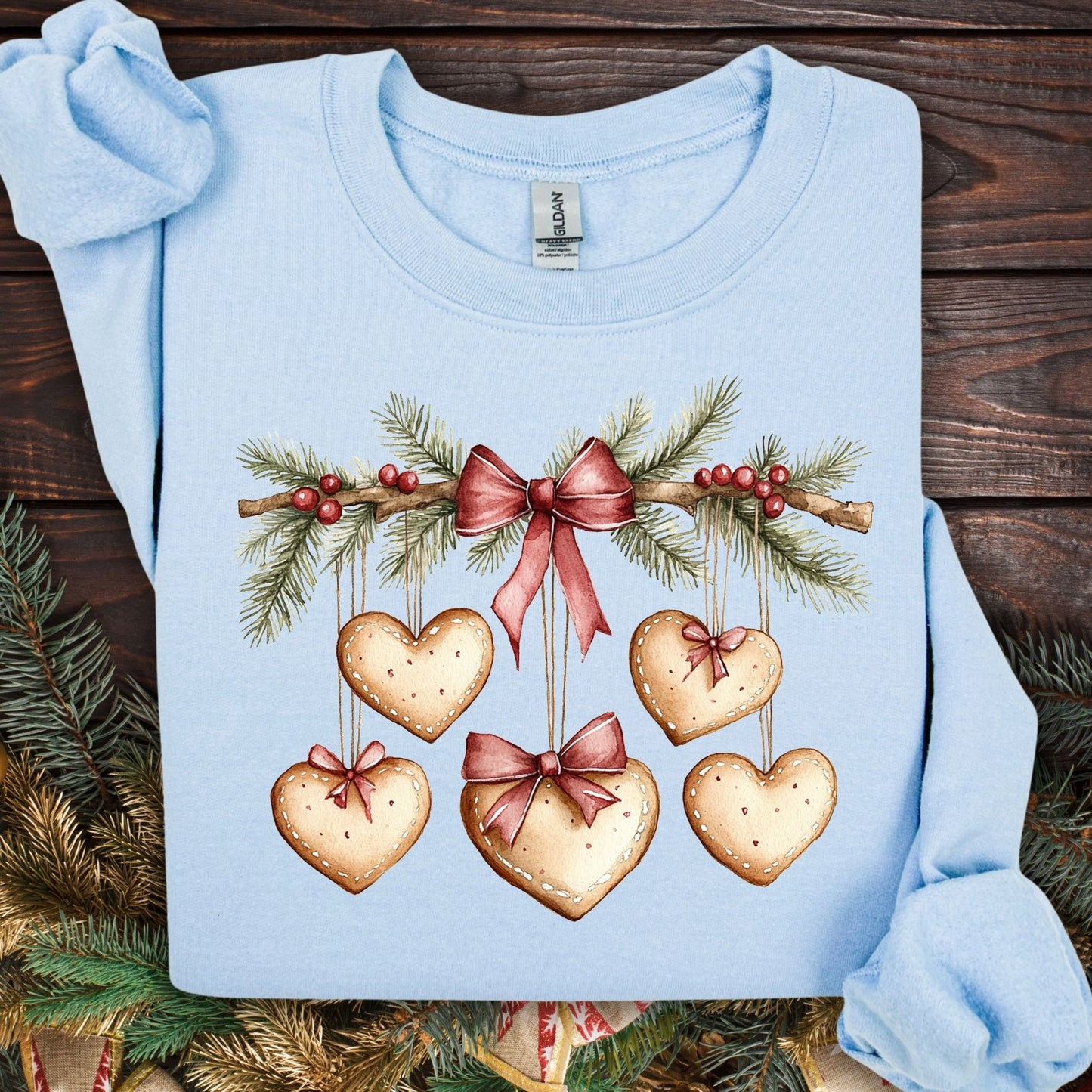 Light blue S sweatshirt with watercolor evergreen garland and heart gingerbread cookies.