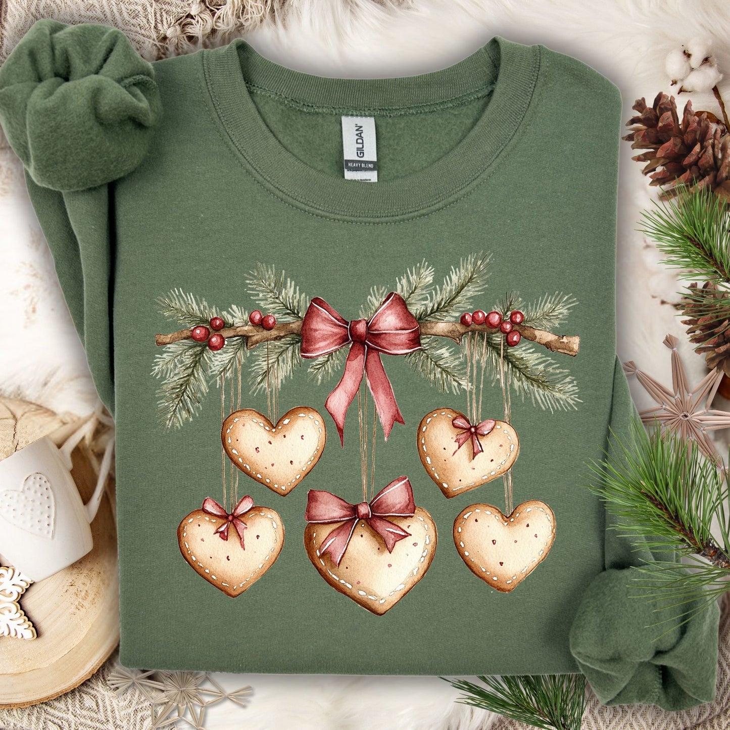 Military Green sweatshirt with watercolor evergreen garland, red bow, and heart-shaped gingerbread cookies.