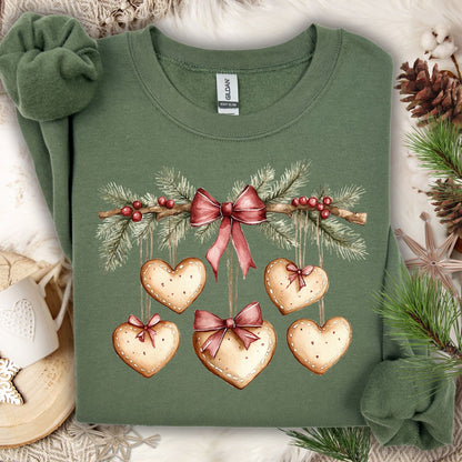 Military Green sweatshirt with watercolor evergreen garland, red bow, and heart-shaped gingerbread cookies.
