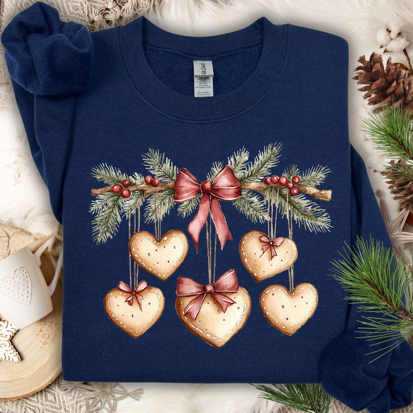 Navy crewneck sweatshirt with watercolor evergreen garland and hanging gingerbread hearts.