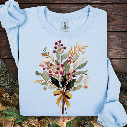 Light blue sweatshirt with a watercolor Christmas bouquet of berries, eucalyptus, evergreens, and a golden bow.