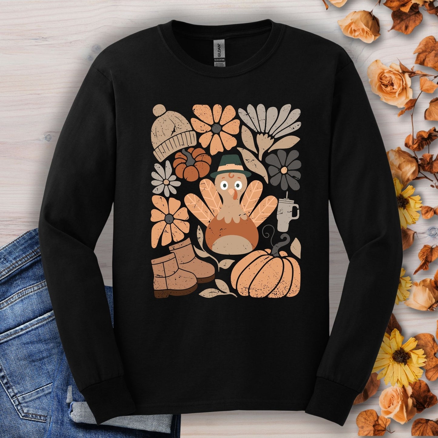 Black long sleeve tee with a groovy turkey, boots, pumpkin, hat, and fall flowers graphic.