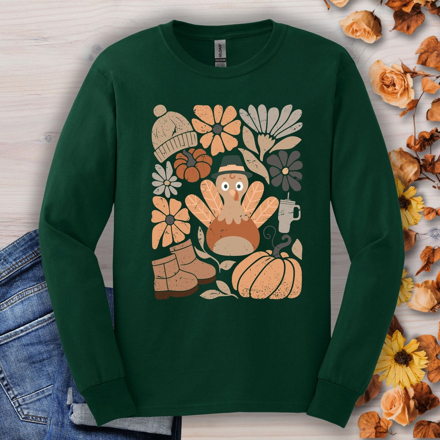 Forest Green long sleeve tee with a "Groovy Turkey" graphic surrounded by fall essentials like boots, pumpkins, and flowers.
