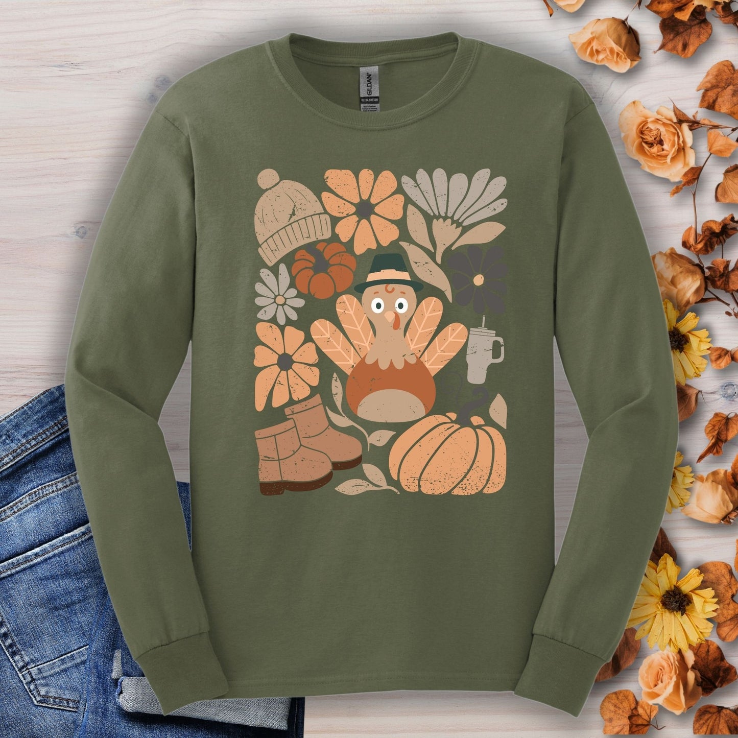 Military Green Gildan 2400 long sleeve tee with a groovy turkey, boots, pumpkin, and fall flowers graphic.