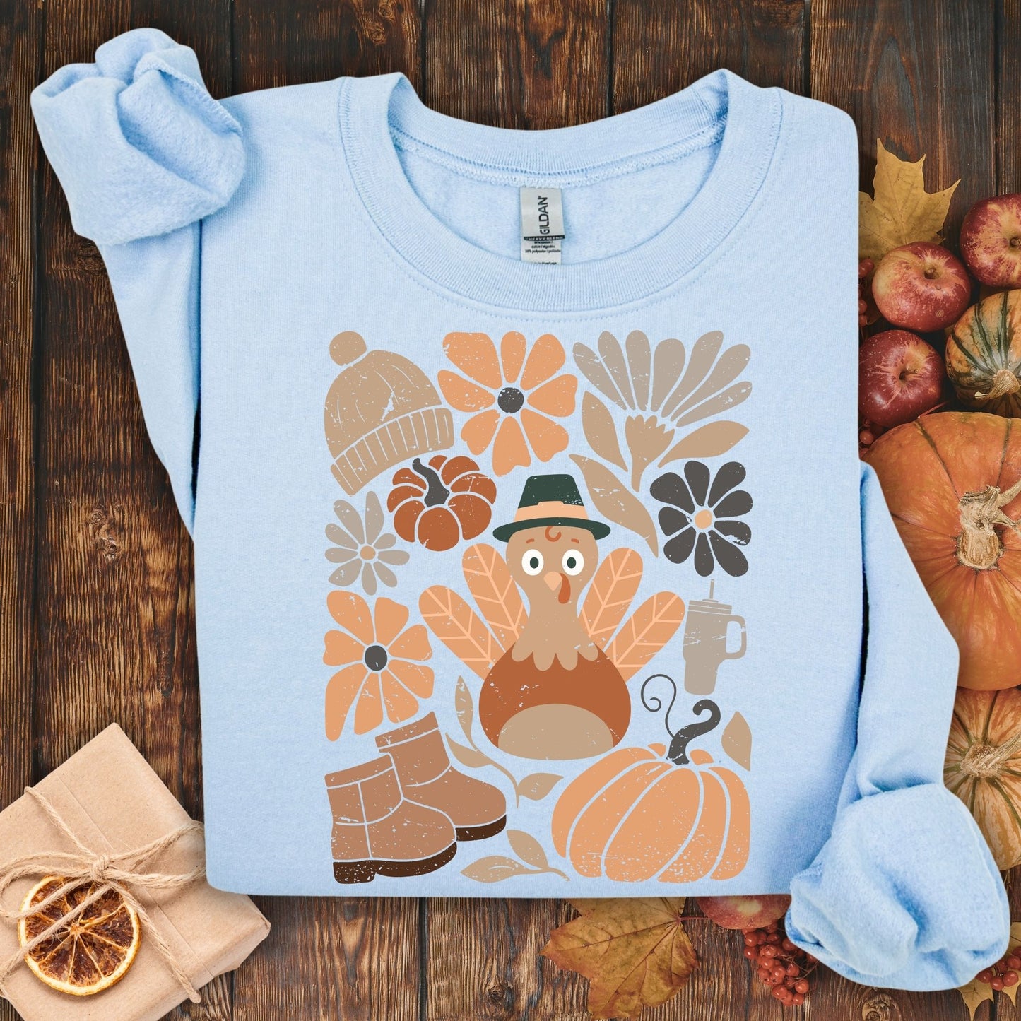 Light blue Gildan sweatshirt with a groovy turkey, fall leaves, boots, hat, and rustic florals.