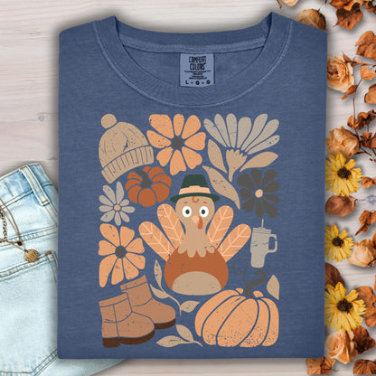 Denim Comfort Colors t-shirt with a groovy turkey, pumpkins, boots, and autumn flowers.