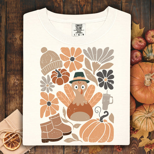Ivory Comfort Colors t-shirt with a groovy turkey, pumpkins, boots, hat, and fall flowers.