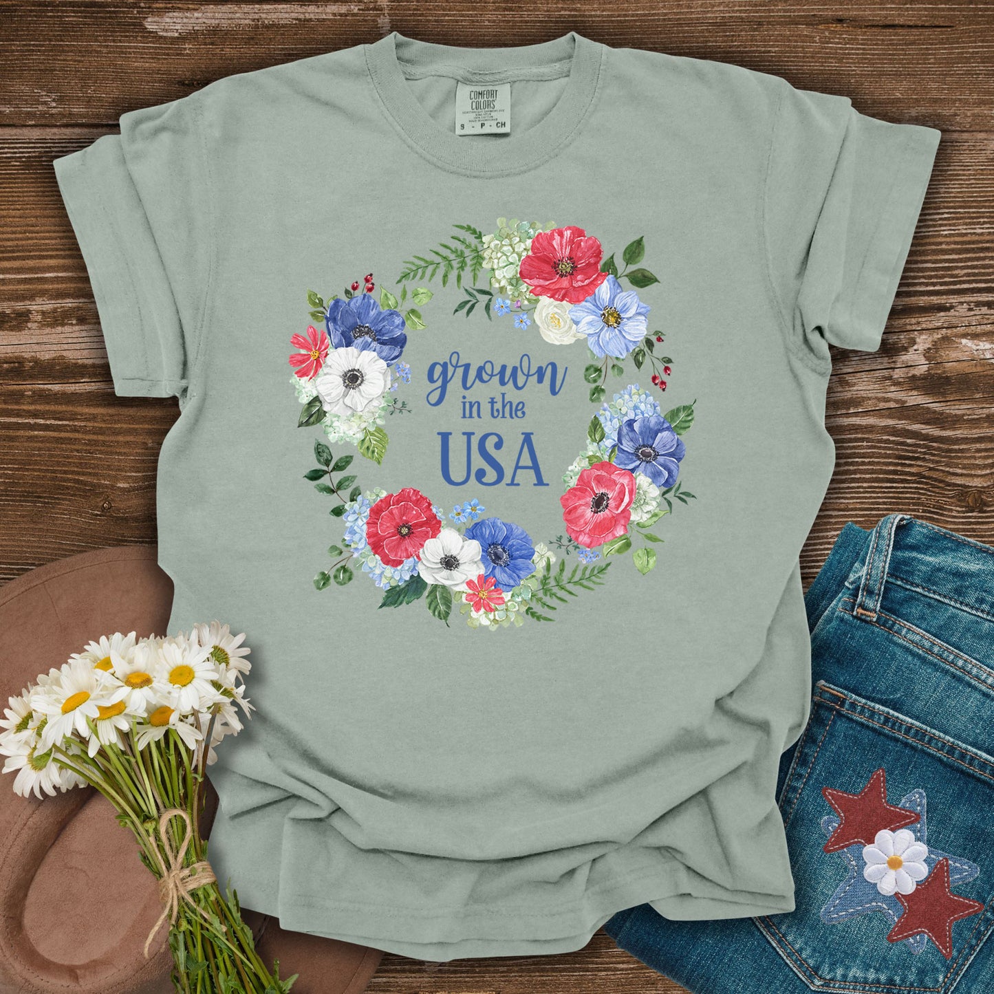 Bay S t-shirt with "Grown in the USA" in a floral wreath of red, white, and blue flowers.