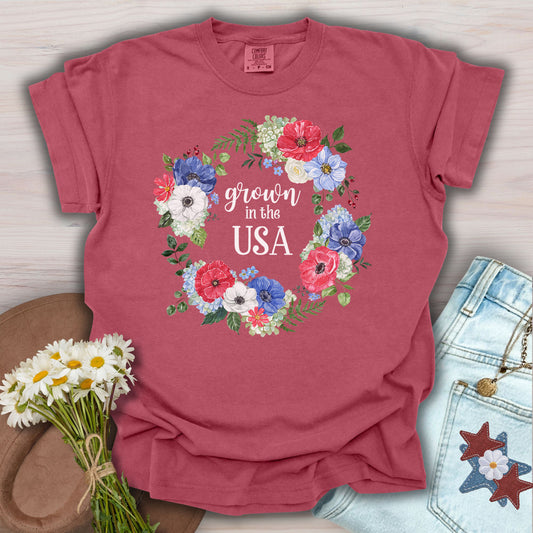 Crimson "Grown in the USA" T-shirt with a watercolor floral wreath of poppies, daisies, and wildflowers.