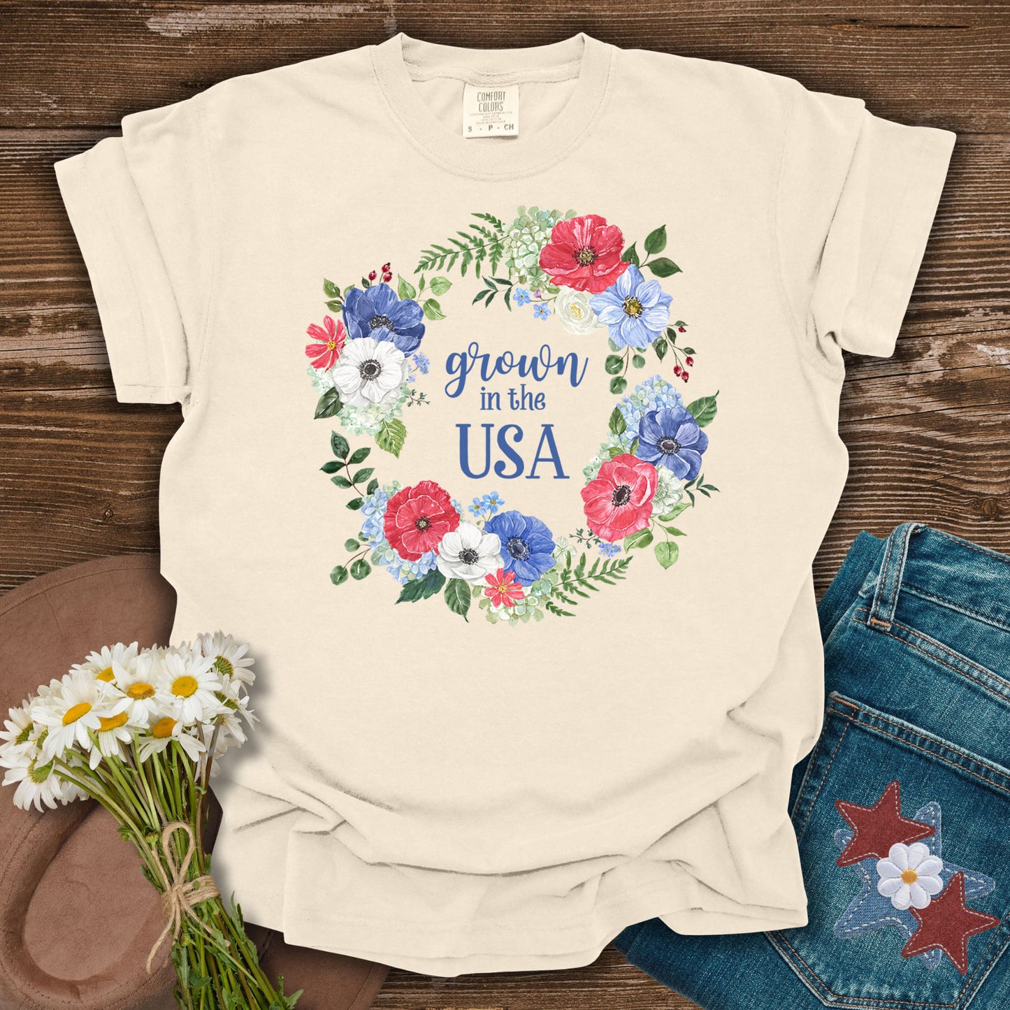 Ivory Grown in the USA t-shirt with a watercolor floral wreath of red, white, and blue poppies and daisies.