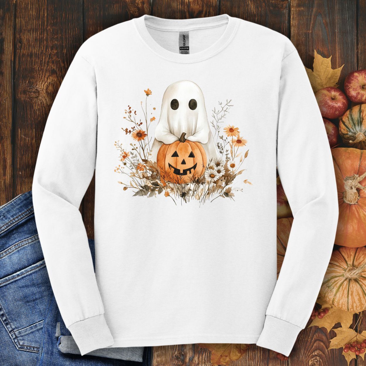 White long-sleeve tee with a boho ghost holding a pumpkin, surrounded by earthy florals.