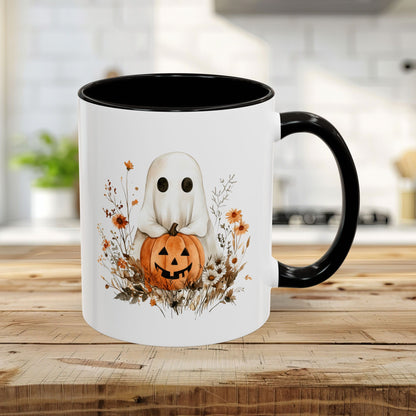 White ceramic 11oz mug with black handle and interior, featuring a watercolor ghost holding a jack o'lantern amidst fall wildflowers.