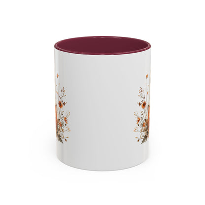 White ceramic mug with a dark red interior and handle, featuring a boho ghost on a jack-o'-lantern with wildflowers.
