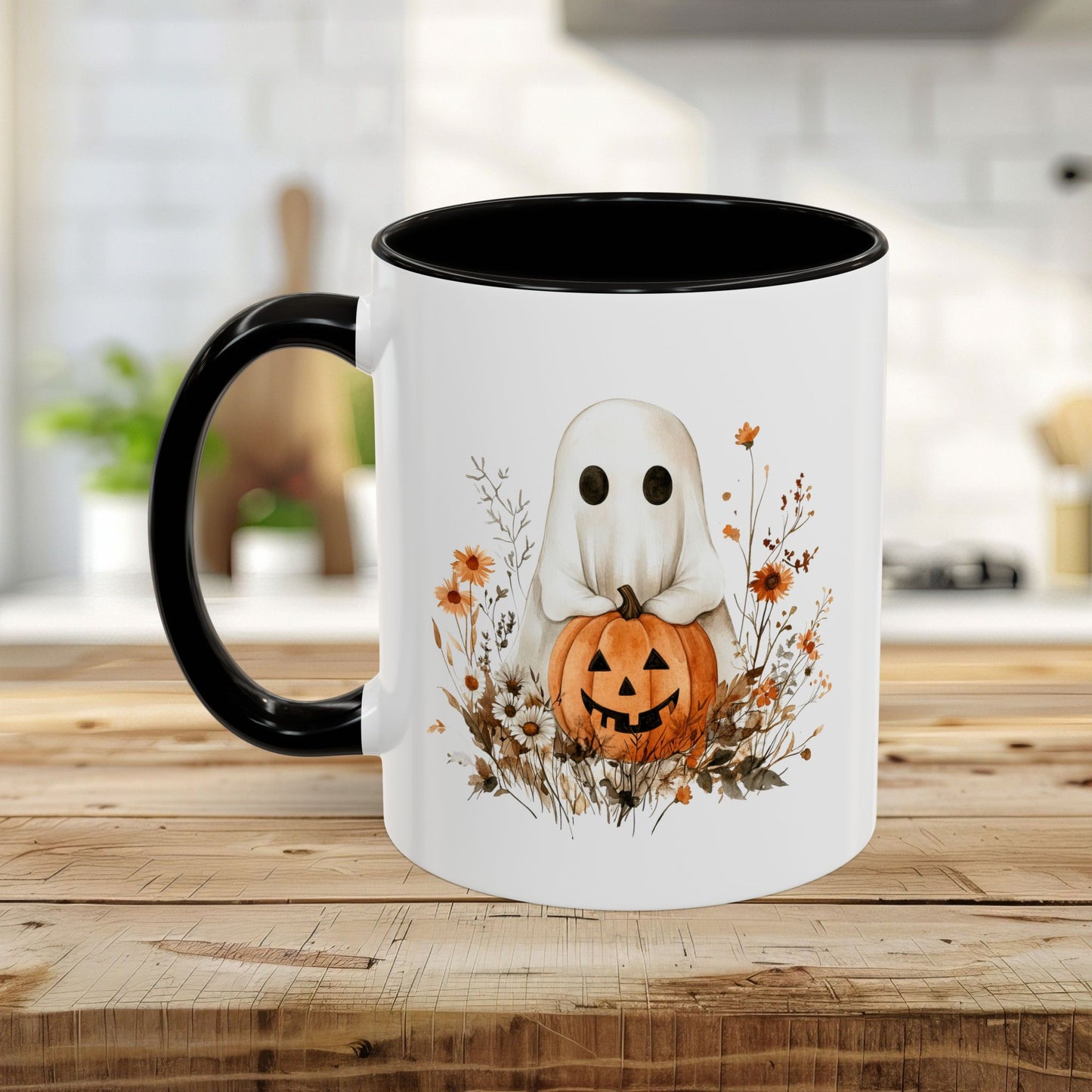 White ceramic mug with black handle and interior, featuring a watercolor ghost holding a jack-o'-lantern amidst wildflowers.