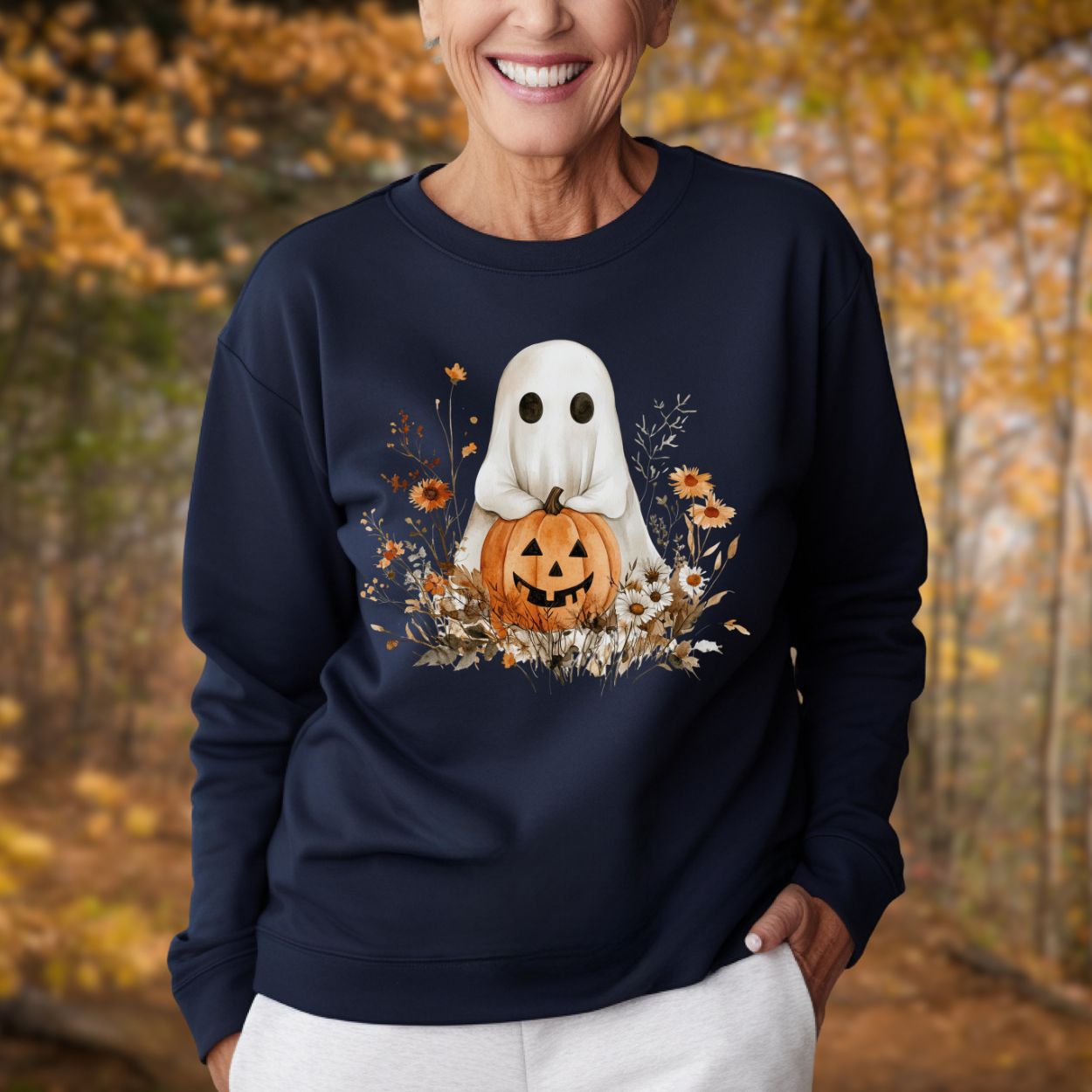 Navy unisex sweatshirt with a cute boho ghost holding a jack o'lantern, surrounded by autumn wildflowers.
