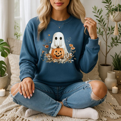 Blonde woman in a blue Halloween Boho Ghost with Jack O'Lantern sweatshirt surrounded by autumn wildflowers.