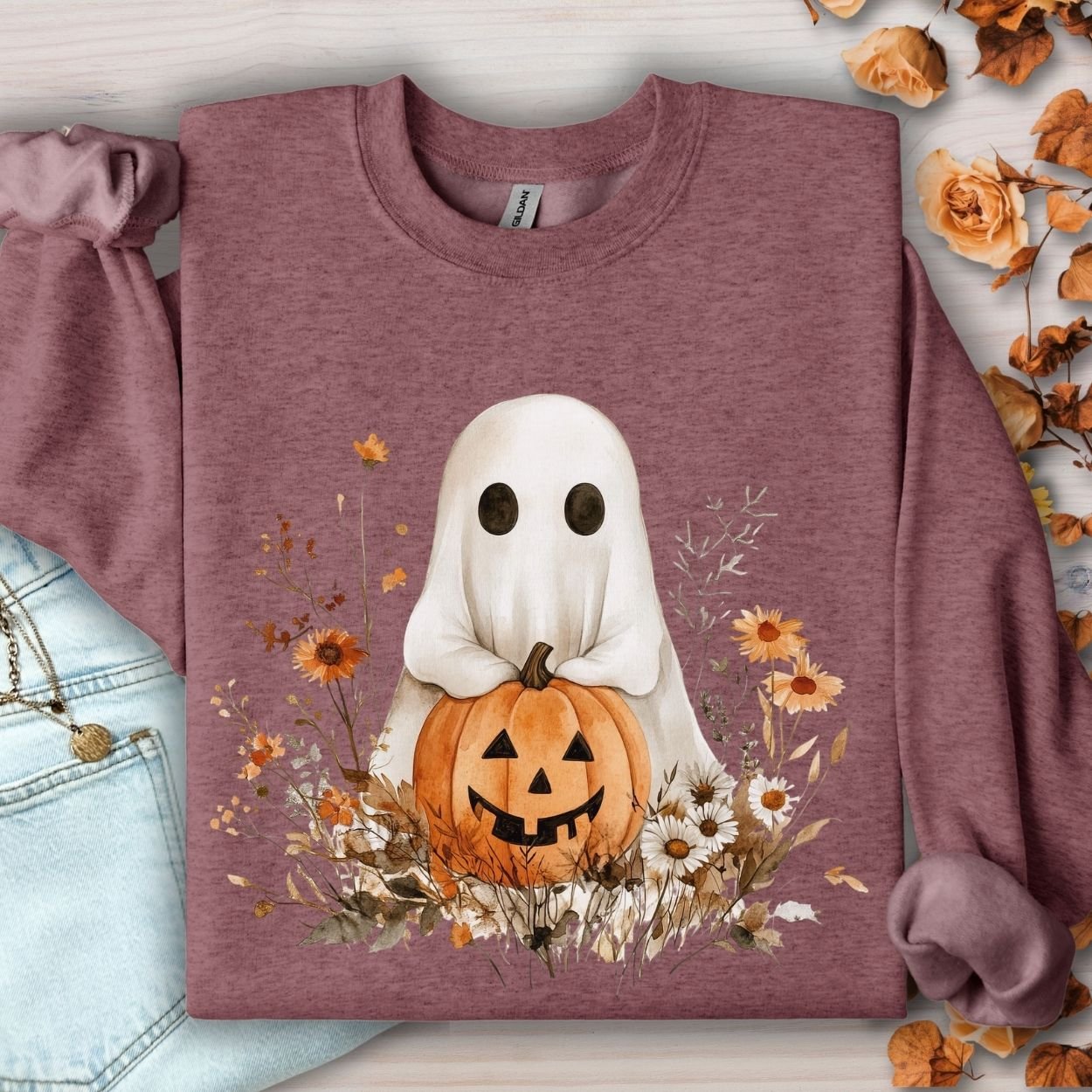 Heather Sport Dark Maroon sweatshirt with a cute ghost holding a jack o'lantern, surrounded by autumn wildflowers.