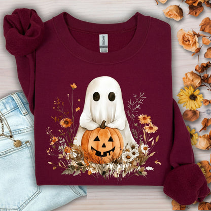 Maroon Gildan sweatshirt with a cute boho ghost holding a jack-o'-lantern, surrounded by autumn wildflowers.