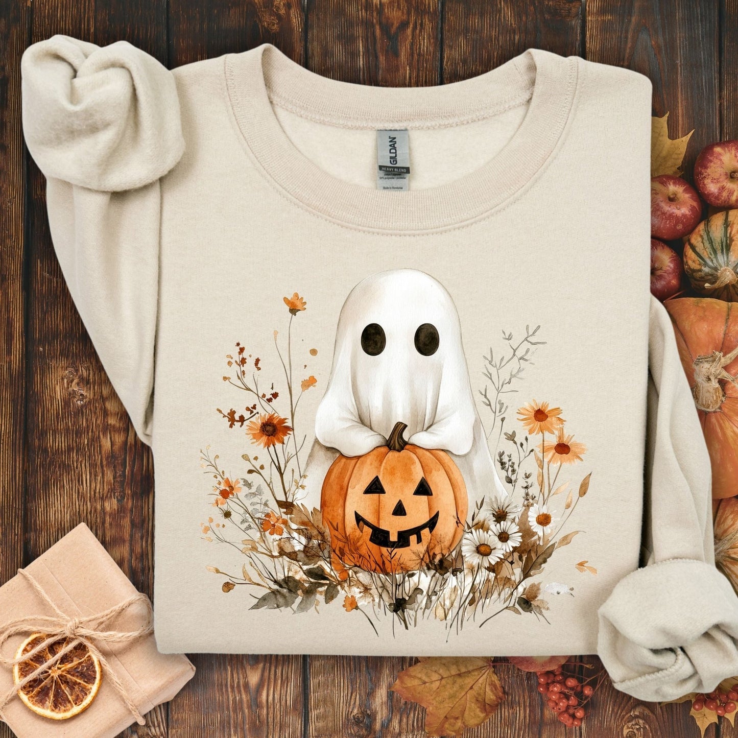 Sand unisex sweatshirt with a cute ghost holding a jack-o'-lantern, surrounded by boho autumn wildflowers.