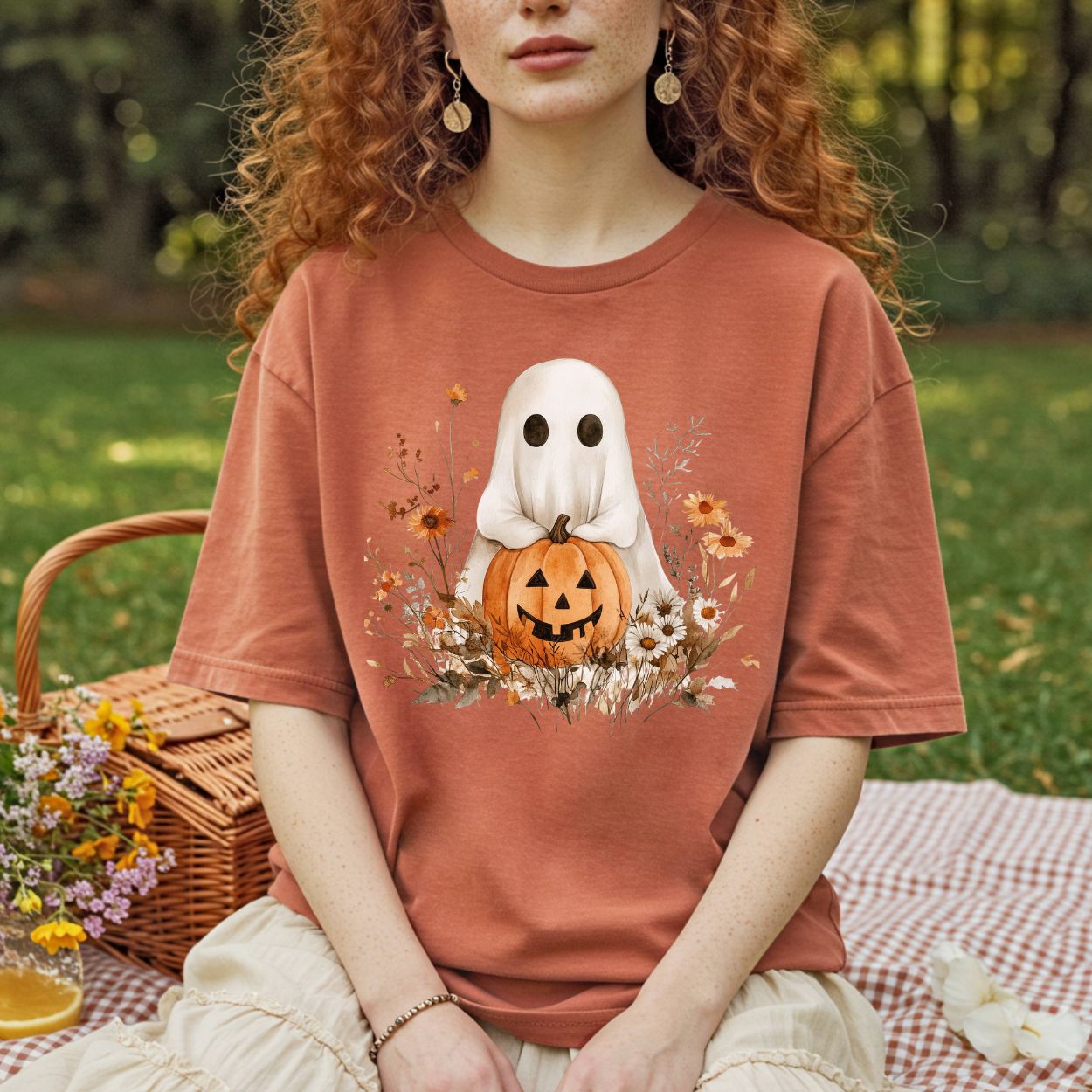 Boho ghost t-shirt in muted orange, featuring a ghost holding a jack-o'-lantern with autumn florals.