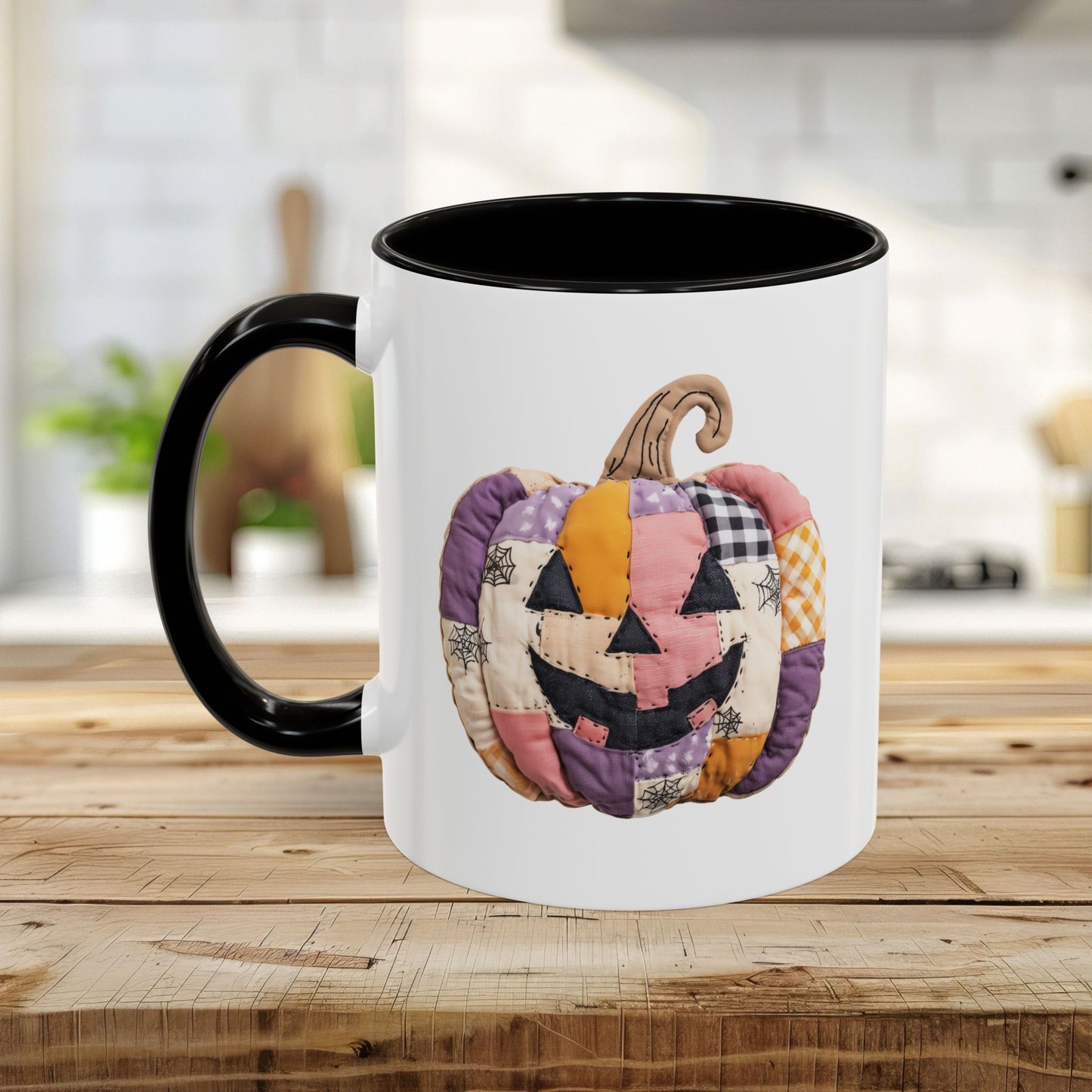 White ceramic mug with black handle and interior, featuring a colorful quilted jack-o'-lantern design.