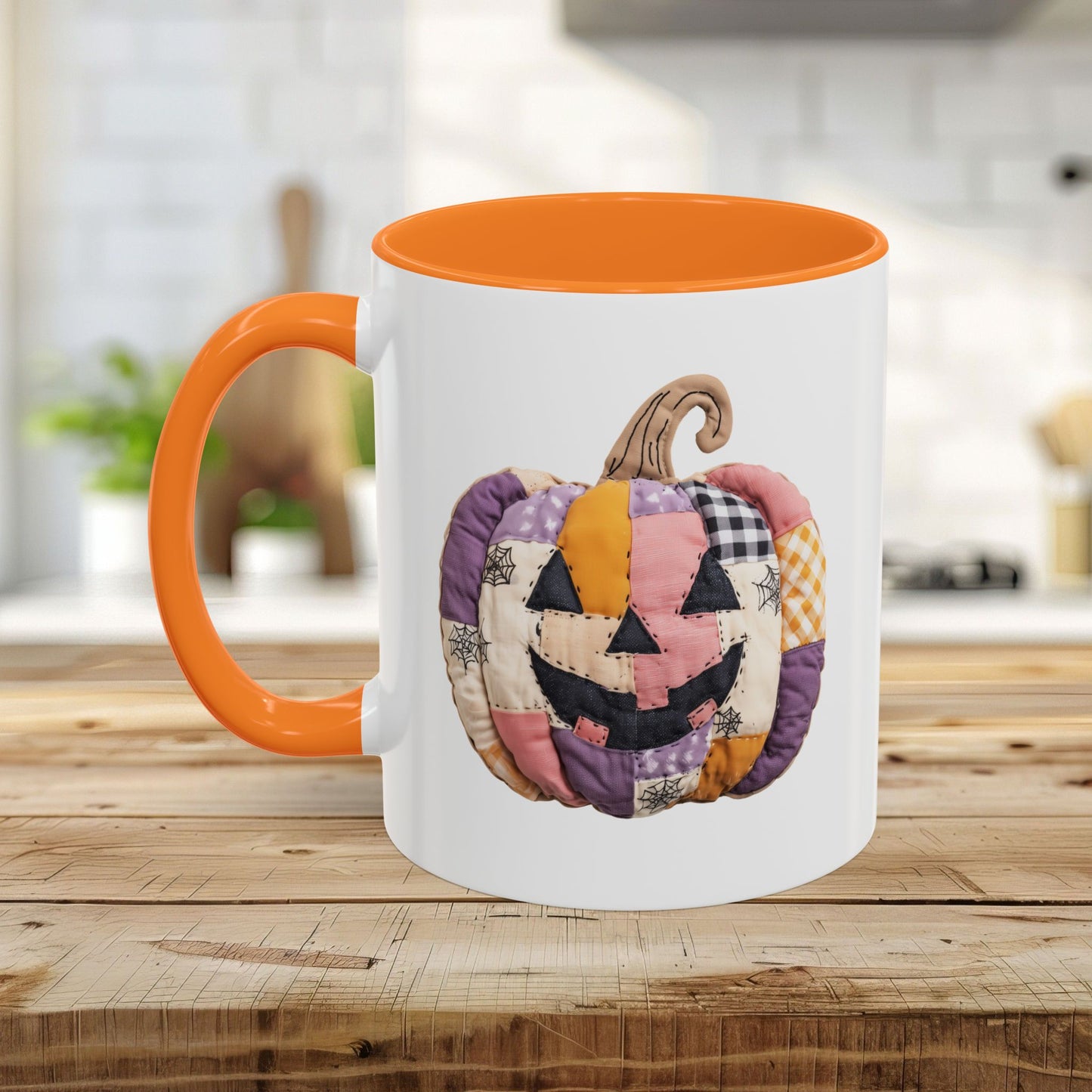 White ceramic mug with orange handle and interior, featuring a quilted patchwork jack-o'-lantern design.