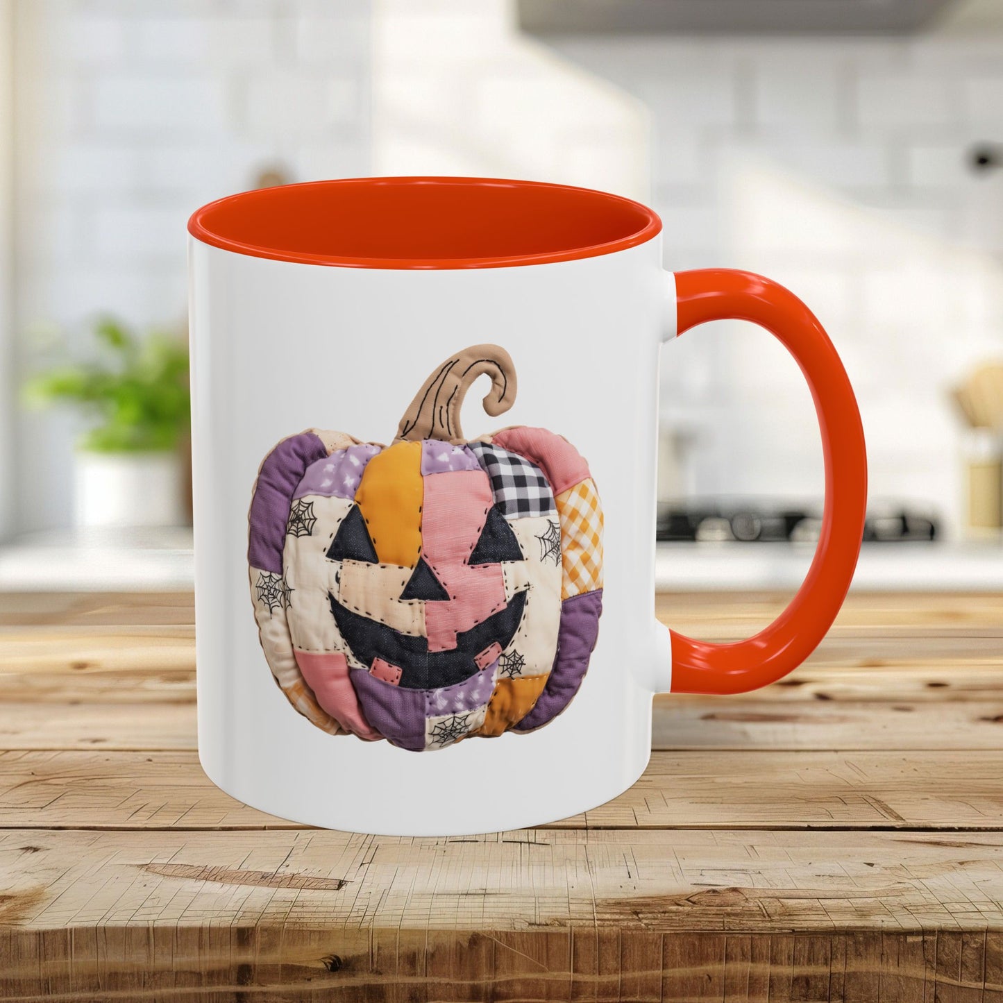 White ceramic 11oz mug with orange handle and interior, featuring a quilted patchwork jack-o'-lantern.