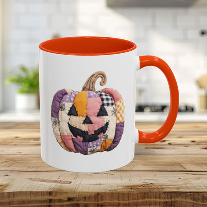 White ceramic 11oz mug with orange handle and interior, featuring a quilted patchwork jack-o'-lantern.