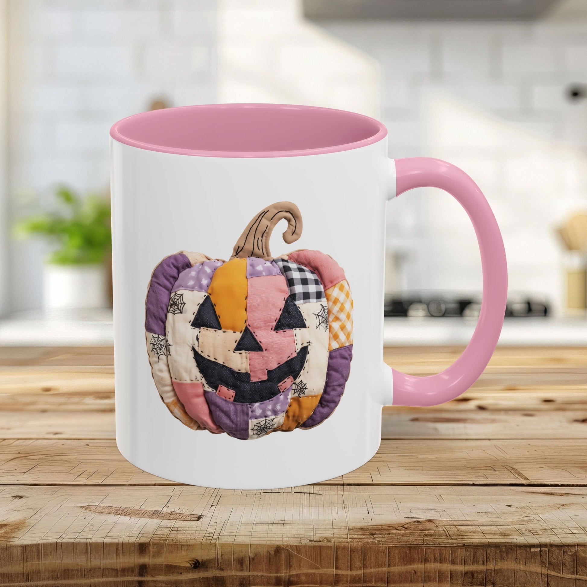 White ceramic 11oz mug with pink handle and interior, featuring a quilted patchwork jack-o'-lantern design.