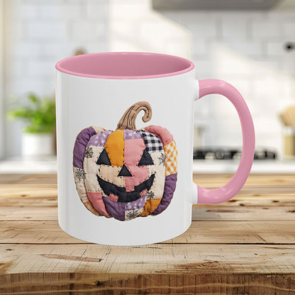 White ceramic 11oz mug with pink handle and interior, featuring a quilted patchwork jack-o'-lantern design.
