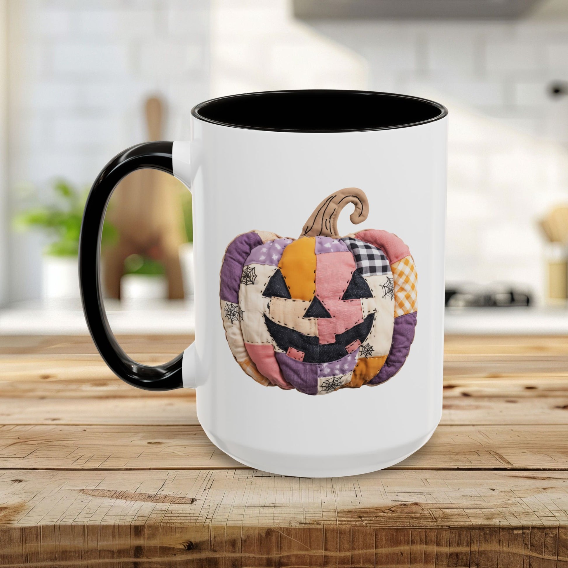 White ceramic mug with black handle and interior, featuring a colorful quilted jack-o'-lantern design.