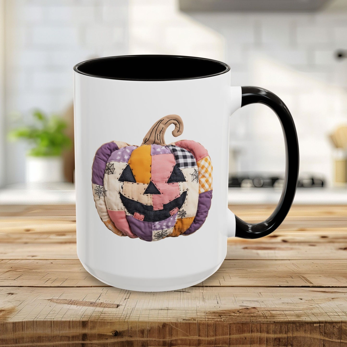 White ceramic 15oz mug with black handle and interior, featuring a quilted patchwork jack-o'-lantern design.