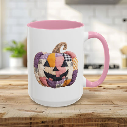 White ceramic 15oz mug with pink handle and interior, featuring a quilted patchwork jack-o'-lantern design.