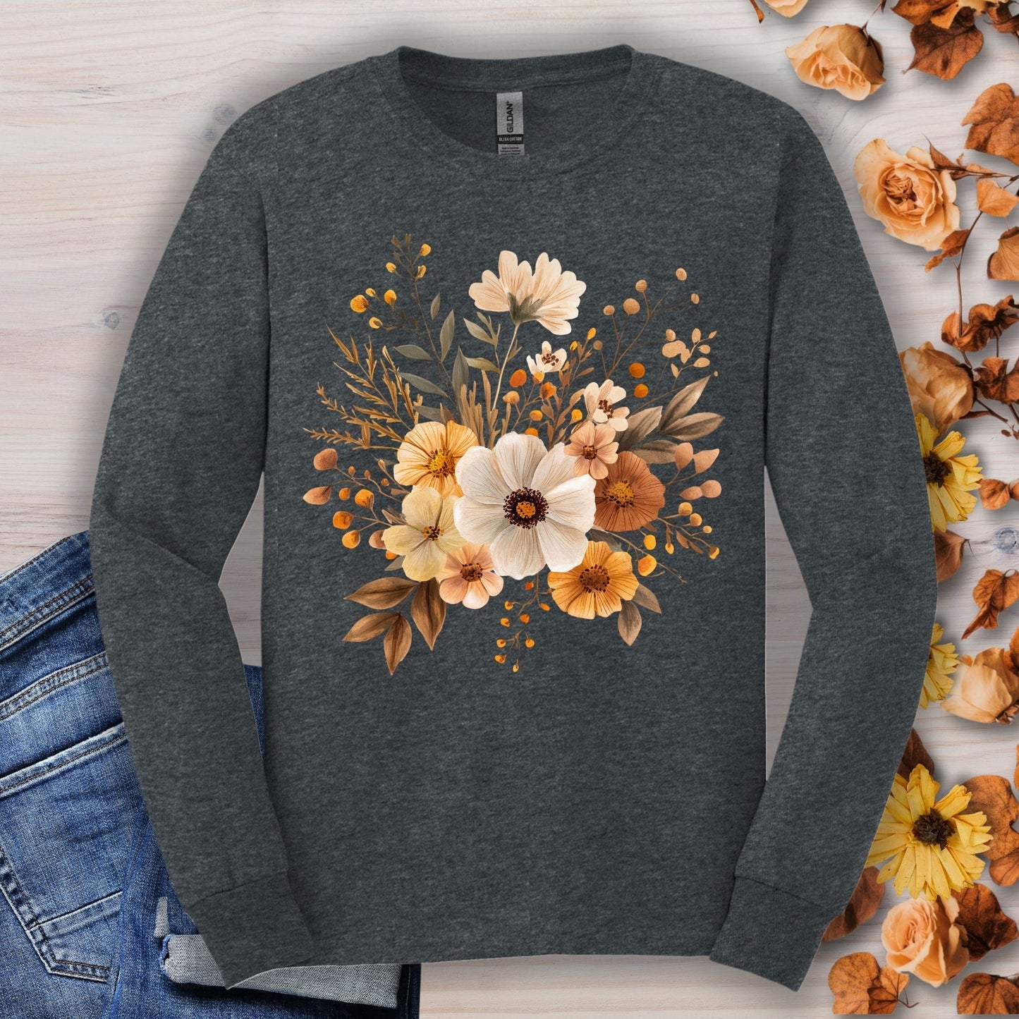 Dark Heather Gildan long sleeve tee with a muted autumn floral design, 100% cotton, shown with jeans.
