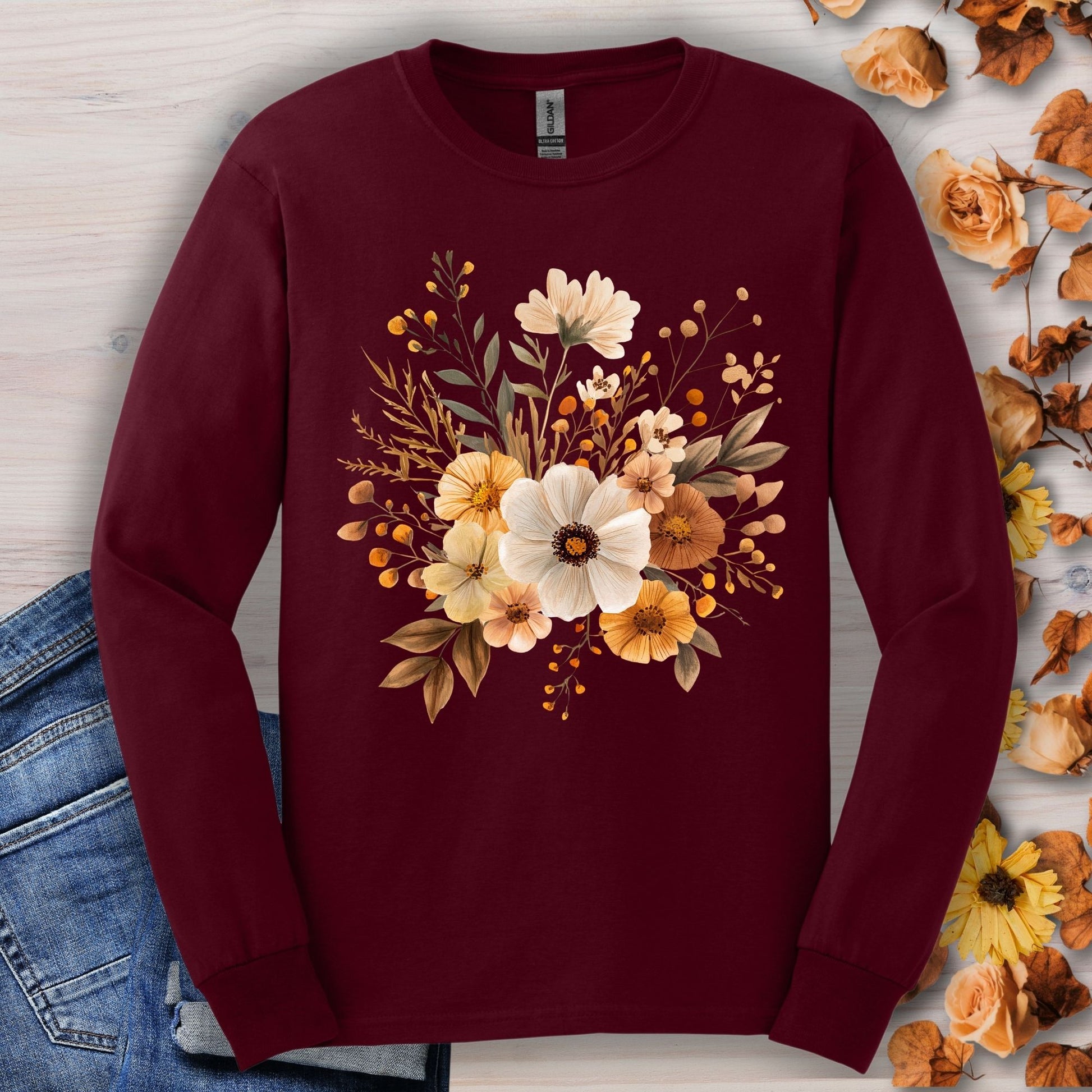 Maroon long-sleeve cotton tee with a cottagecore design of muted autumn flowers, shown with jeans.