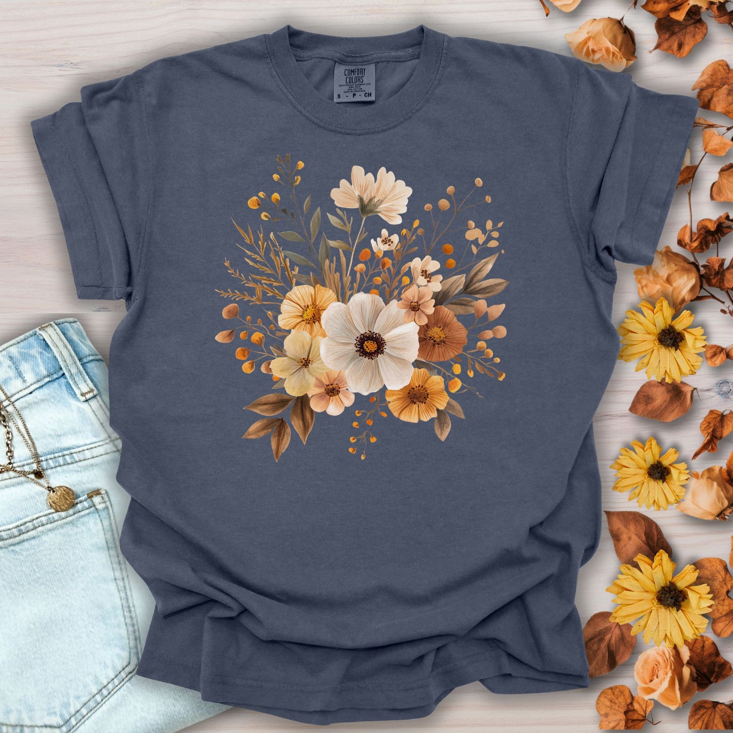 Denim blue garment-dyed t-shirt with a warm bouquet of autumn-hued blooms at the chest.
