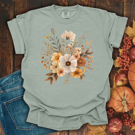 Garment-dyed Bay Harvest Blooms T-Shirt (size S) with autumn floral design, next to jeans and pumpkins.