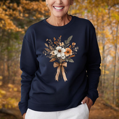 Woman in a navy sweatshirt with a watercolor autumn floral bouquet and light brown bow.
