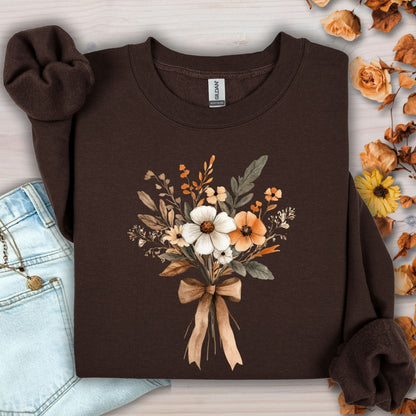 Dark chocolate sweatshirt with a watercolor harvest bouquet of white, orange, and brown flowers tied with a bow.