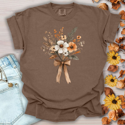 Espresso Harvest Bouquet T-Shirt with watercolor fall flowers and a ribbon, next to jeans and autumn leaves.