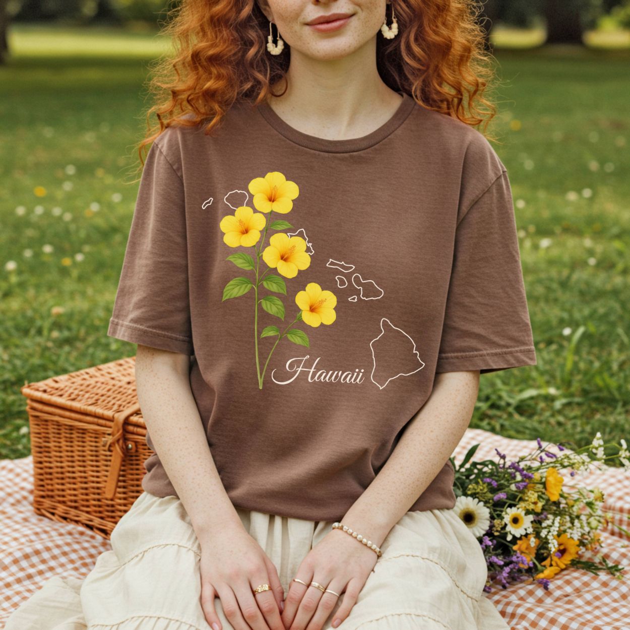 Garment-dyed brown t-shirt with yellow hibiscus flowers and a white outline of the Hawaiian islands.