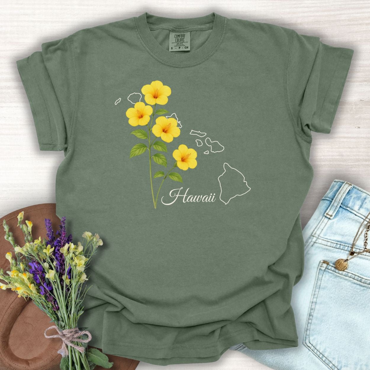 Moss green garment-dyed t-shirt with yellow hibiscus flowers and a Hawaii island outline.