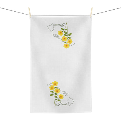 White microfiber tea towel with yellow hibiscus flowers and a subtle Hawaii map design.