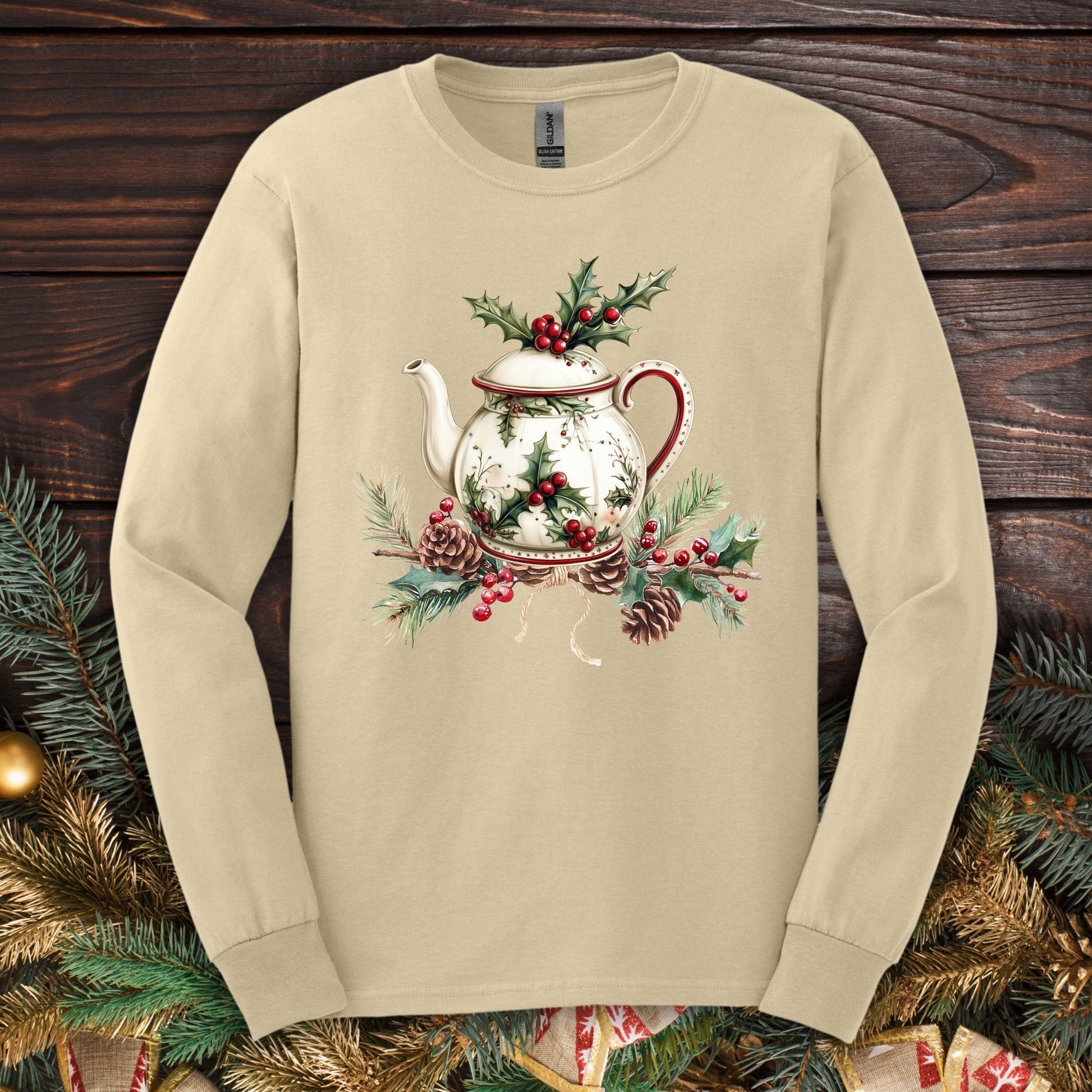 Sand long-sleeve tee with watercolor Christmas teapot, holly, and pinecone design.